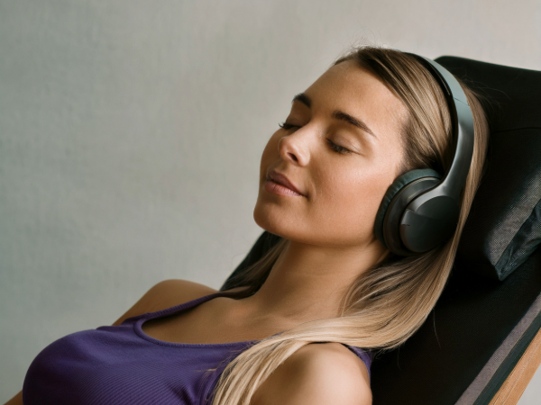 VAVE Frequency Therapy Session Woman relaxing with headphones during a VAVE frequency therapy session on a wellness platform.